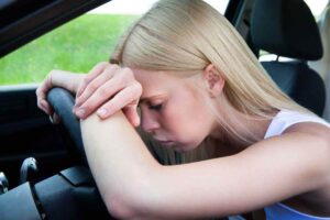 Donna con testa sul volante