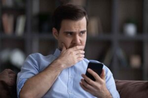 Uomo dubbioso al cellulare