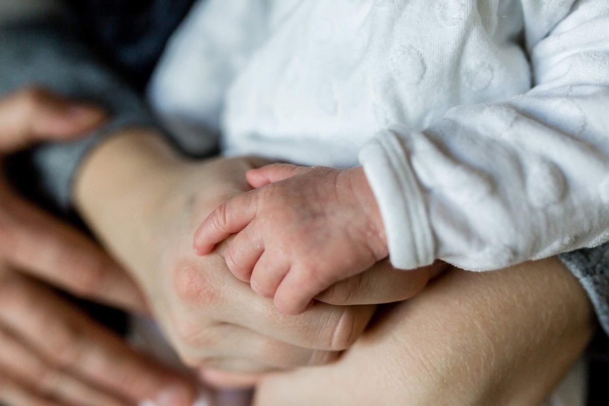 persone con in braccio un bambino piccolo