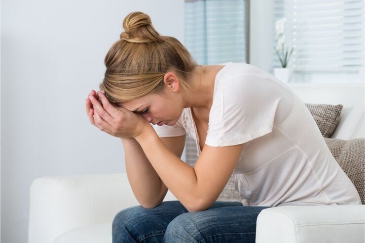 Donna preoccupata con mani nel viso
