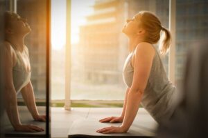 Donna rivolta al sole su un tappetino di ginnastica