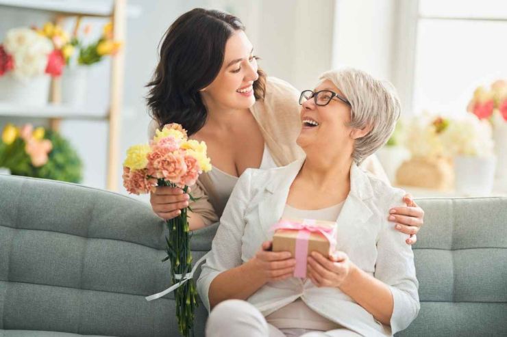 Mamma e figlia con regalo e fiori