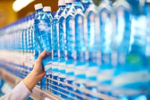 persona che prende l'acqua dallo scaffale