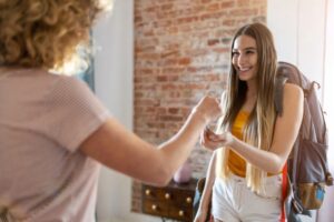 donna che consegna delle chiavi ad una ragazza che sorride
