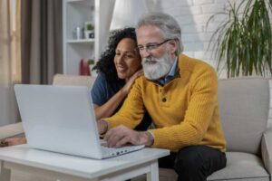 uomo e donna davanti al pc felici