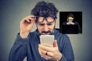 uomo che si alza gli occhiali sulla testa e con il cellulare in una mano