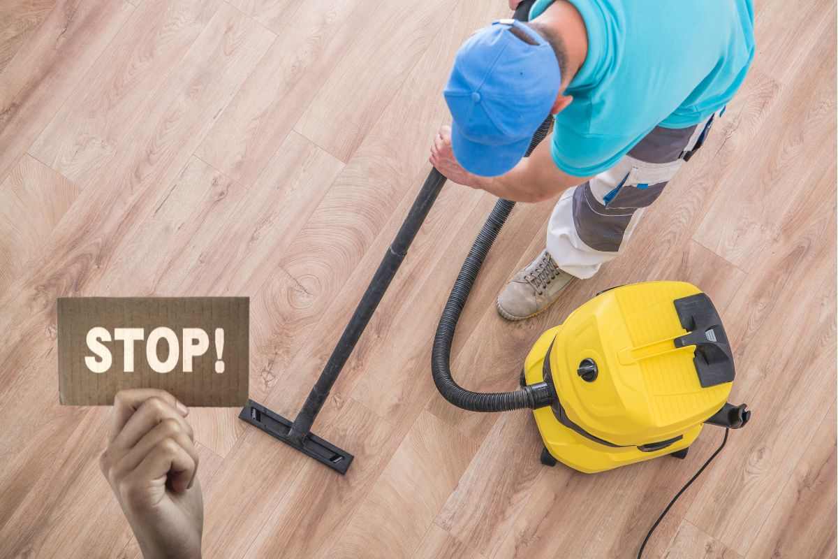 un uomo sta passando per terra l'aspirapolvere