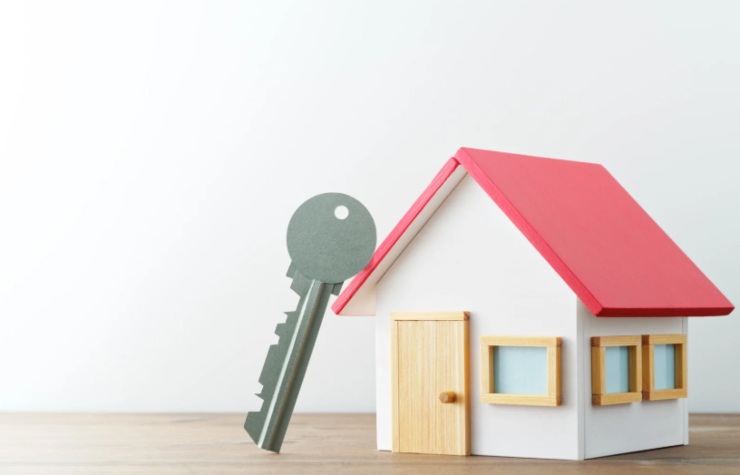 casetta in miniatura con una chiave appoggiata al tetto