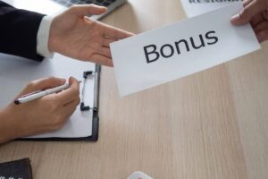 il datore di lavoro che passa una busta al lavoratore con la scritta bonus