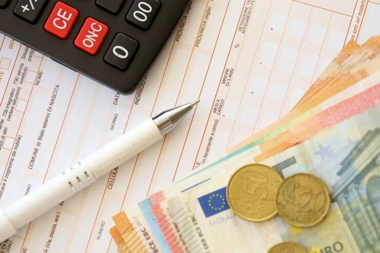 Modello 730, penna, calcolatrice, banconote e monete euro