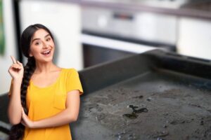 Ragazza con dito alzato, teglia del forno sporca