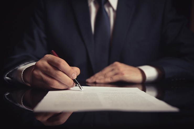 uomo che firma il contratto