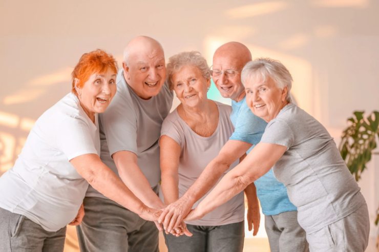 persone anziane che sorridono e uniscono le mani