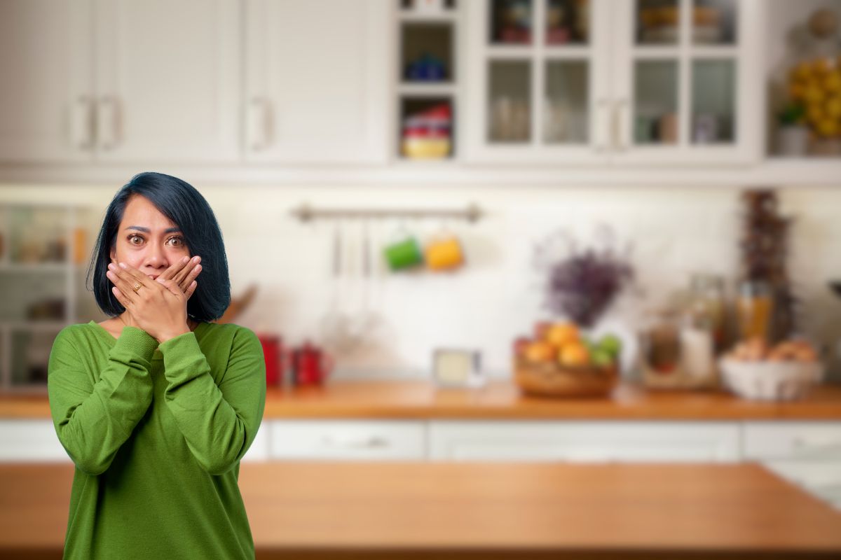 cucina sullo sfondo e donna spaventata