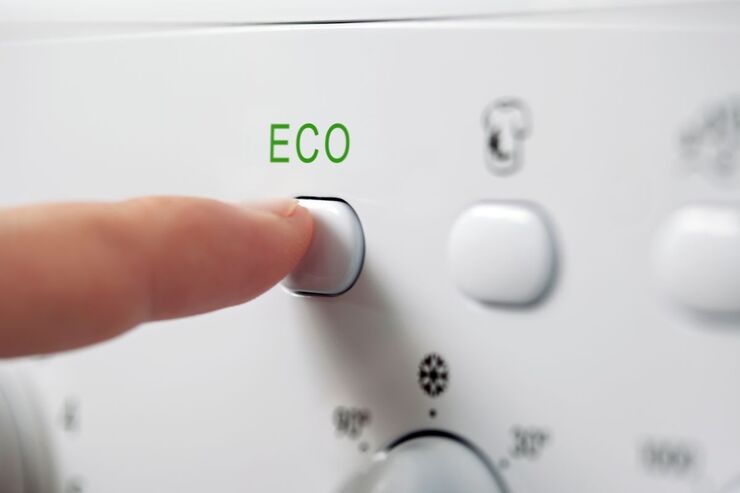 Dito schiaccia "ECO" su lavatrice