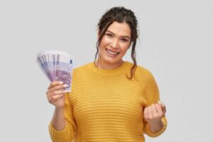 donna che sorride con tante banconote di euro in mano