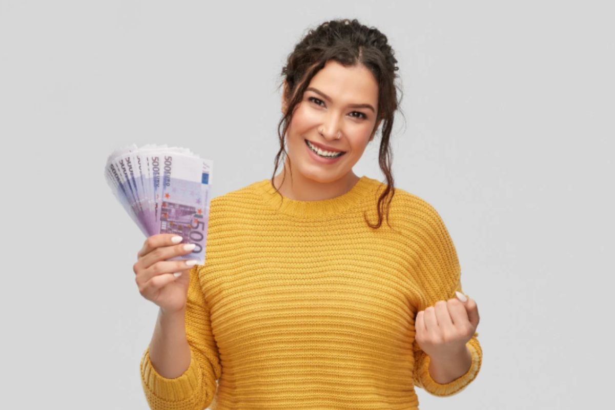 donna che sorride con tante banconote di euro in mano