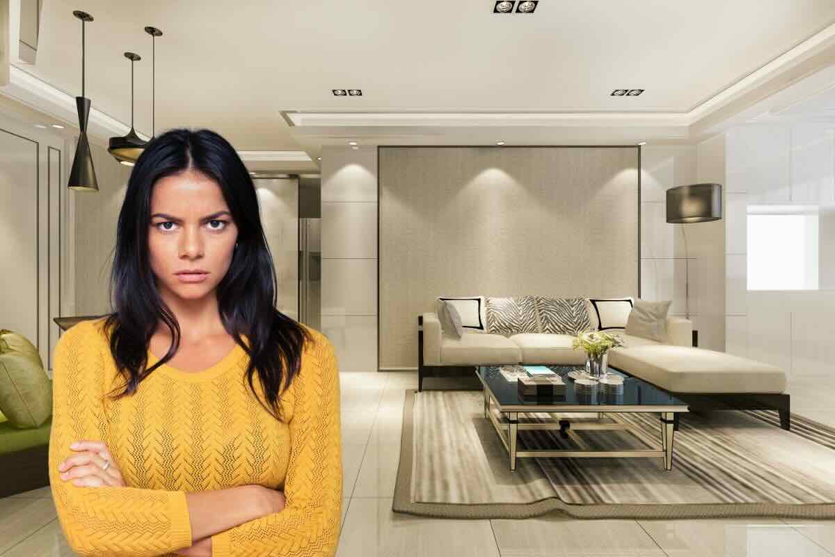 Donna corrucciata braccia conserte e sullo sfondo salone casa