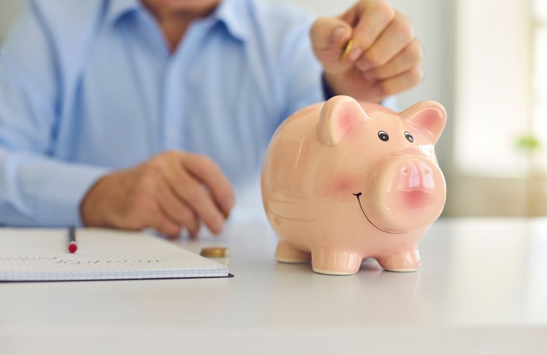 un pensionato che mette i soldi nel salvadanaio