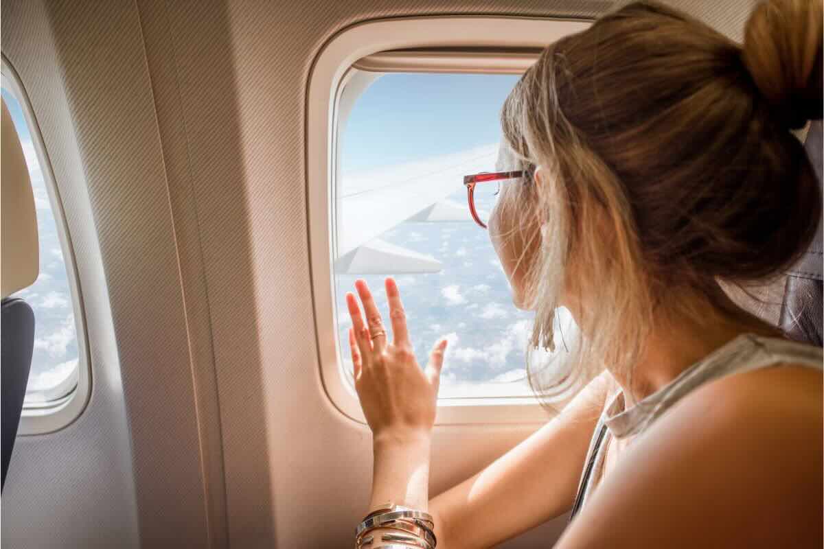 Ragazza guarda fuori dal finestrino in aereo