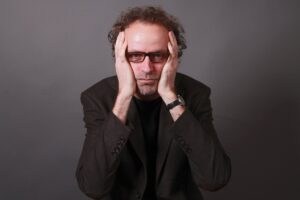 uomo preoccupato con la faccia tra le mani