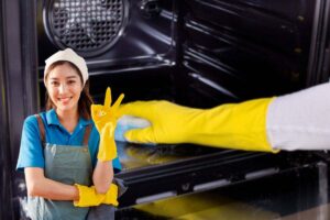 donna che pulisce forno e un'altra che fa ok con le mani