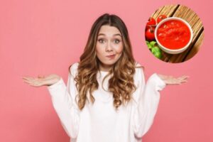 ragazza con le mani aperte e l'espressione dubbiosa e nel riquadro una ciotola con della passata di pomodoro