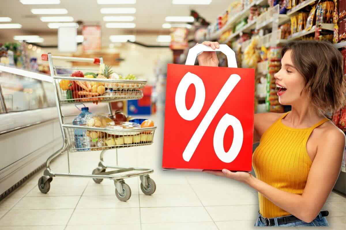 Ragazza tiene in mano busta rossa con simbolo %, sul fondo scaffali supermercato e carrello spesa