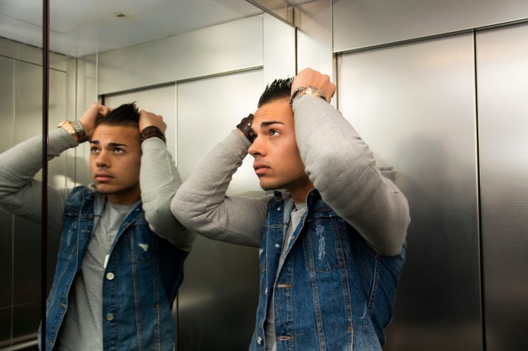 uomo che si specchia in ascensore