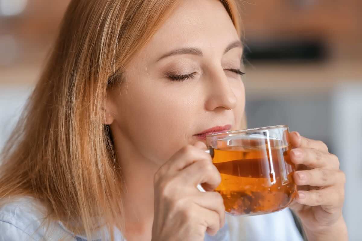 Donna beve tazza di tè