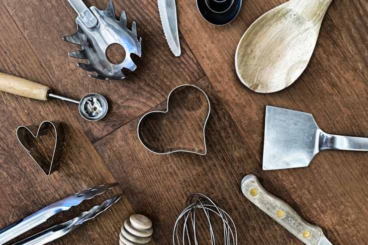 utensili per cucinare sul tavolo messi in torno ad una formina da cucina a forma di cuore