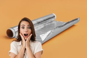 donna stupita e rotolo di carta argenata