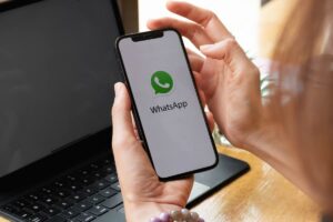 mani che tengono smartphone con app whatsapp