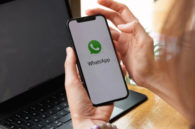 persona con in mano un cellulare e sullo schermo l'icona di whatsapp
