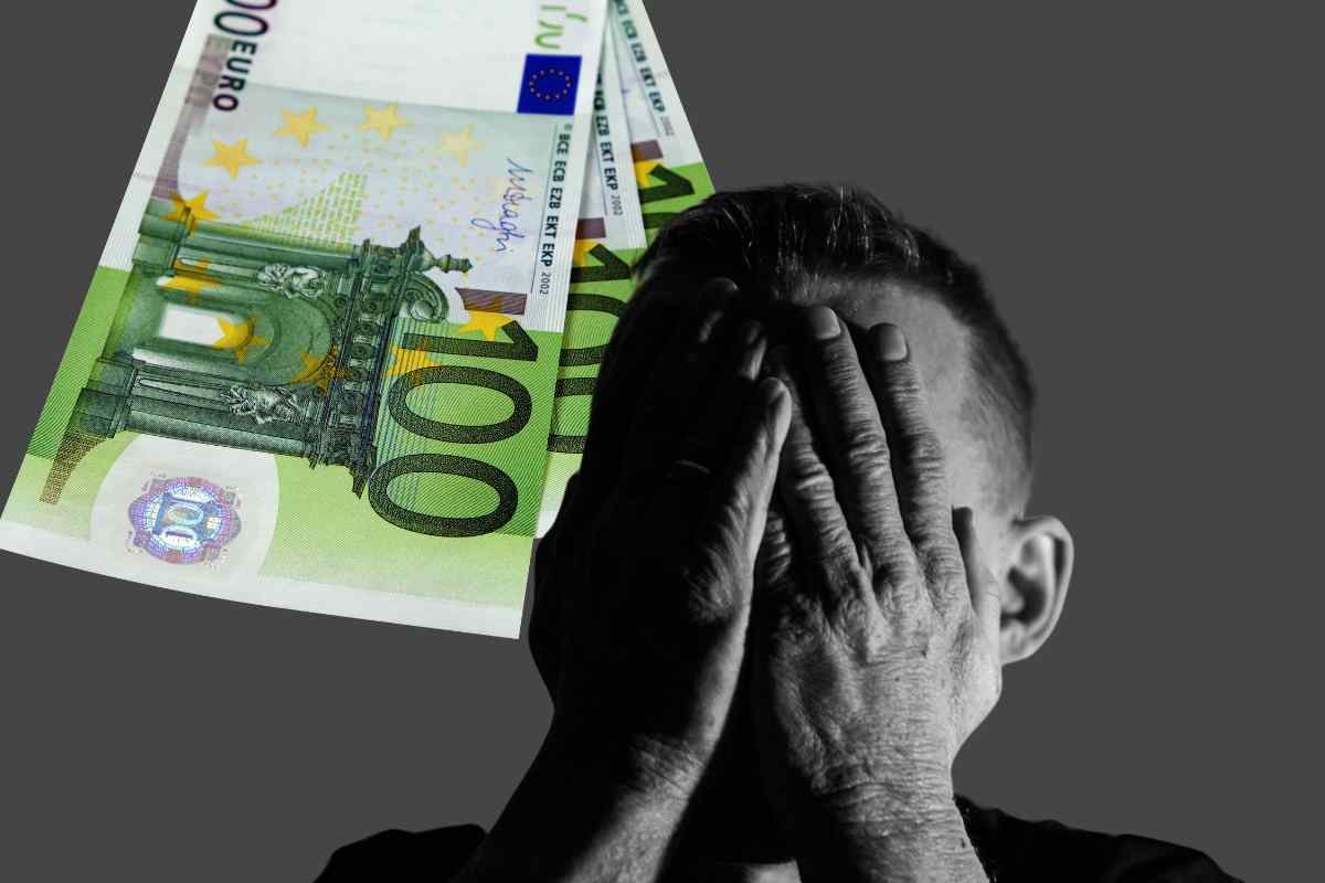 Uomo con mani sul volto e soldi