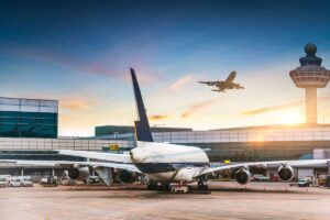Un aereo rivolto verso l'aeroporto che fa da sfondo