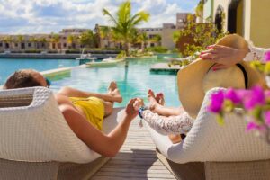 coppia che si gode una vacanza lussuosa su un sdraio davanti ad una piscina