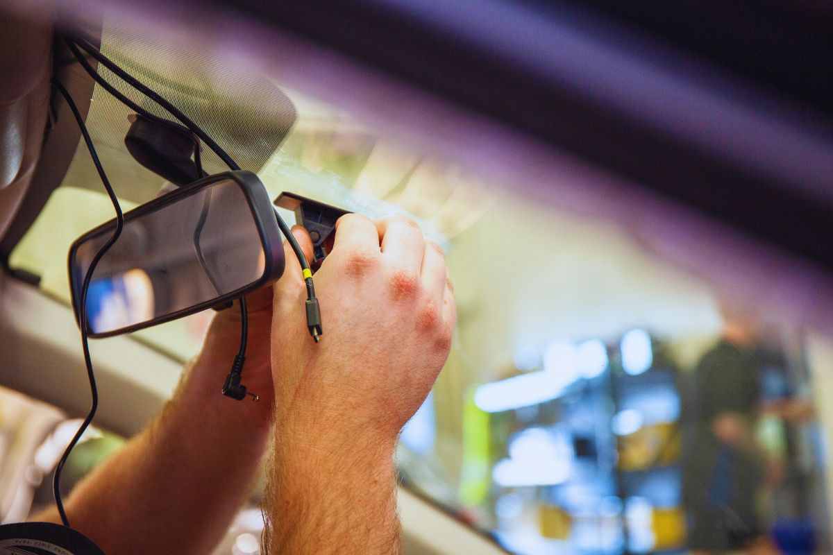 Persona che installa una dashcam sul parabrezza