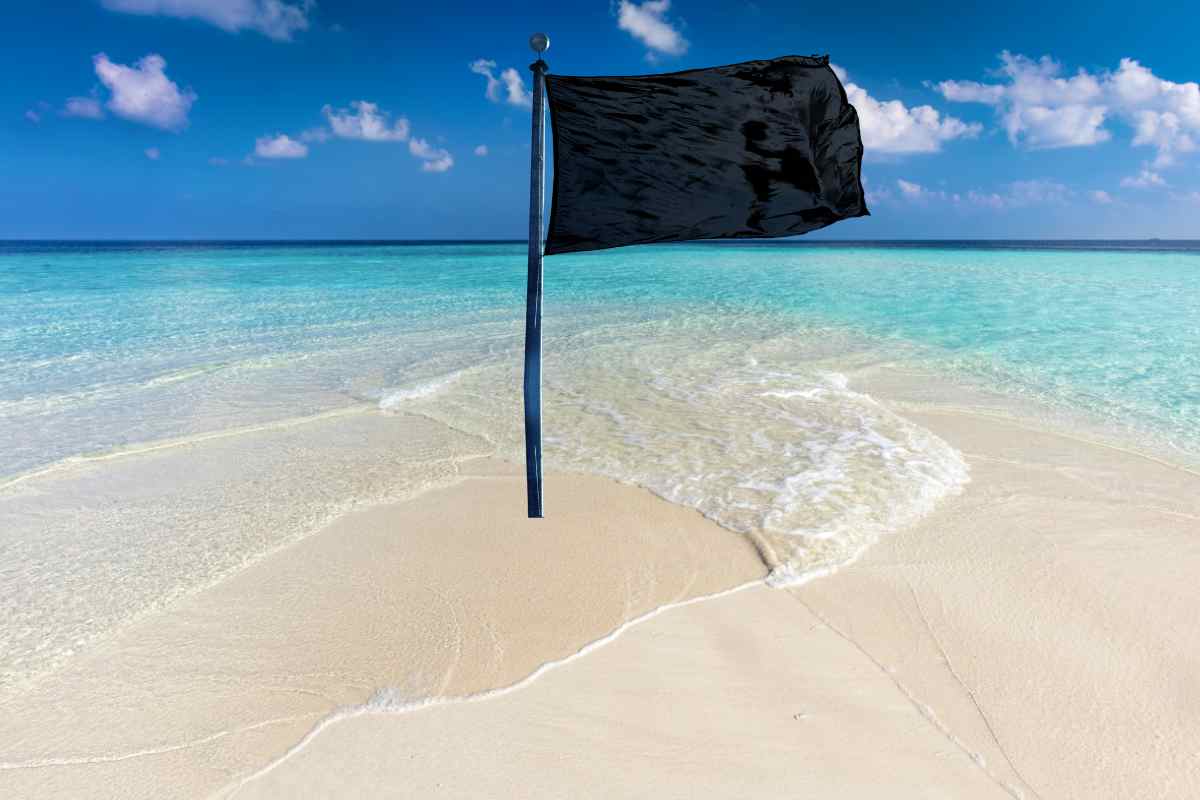 una bellissima piaggia con una bandiera nera