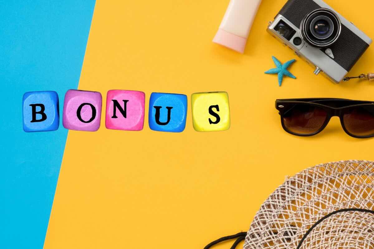Scritta bonus e su fondo colorato crema solare, macchina fotografica, occhiali da sole, cappello