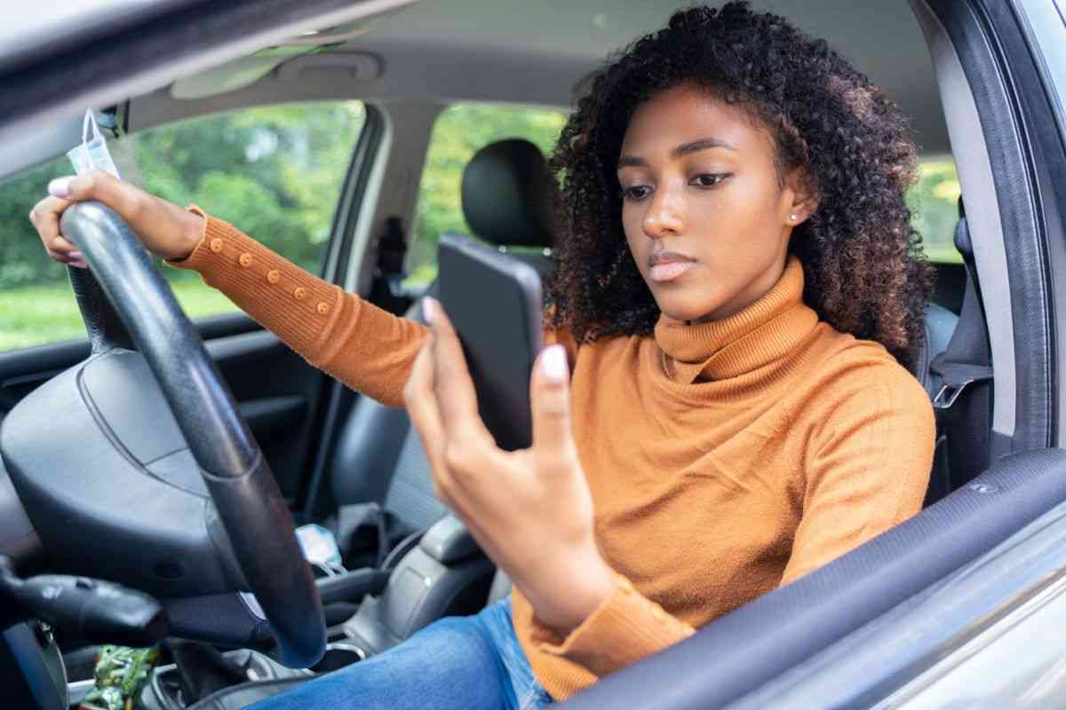 donna usa cellulare in auto