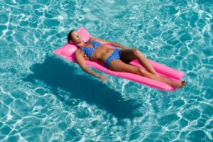 donna che prende il sole sul materassino in acqua