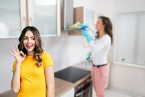 donna che pulisce cappa in cucina e un'altra che fa ok con le mani