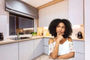 una cucina e una signora dubbiosa