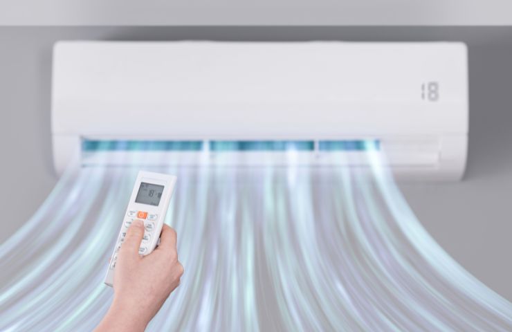 aria fredda che esce dal condizionatore e mano che usa telecomando