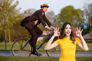 un signore che va in bicicletta al lavoro ed una ragazza che fa ok