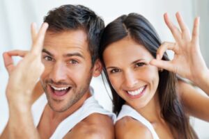 coppia di uomo e donna che sorridono e fanno ok con le dita