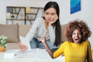 donna che controlla bolletta e un'altra che urla