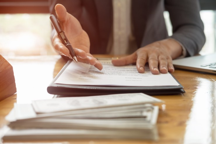 uomo che propone un contratto e dei soldi