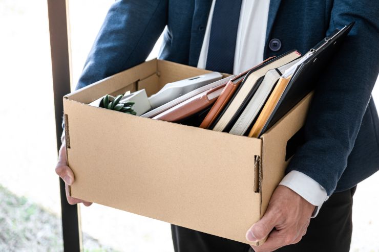 uomo con una scatole con dentro le sue cose dato che è stato licenziato
